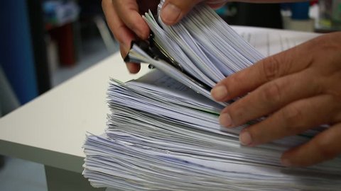 Working in Stack of paper files on work desk in office