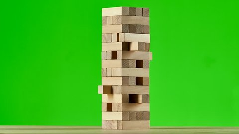 Wooden puzzles jenga gather in tall tower. Stop motion, green screen