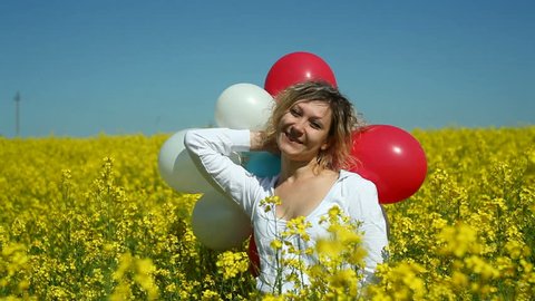 girl with balloons in field