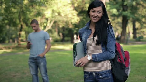 Portrait of young happy female student in the park
