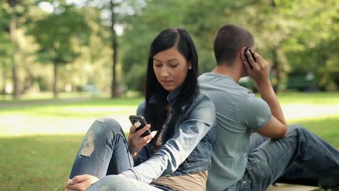Young teenage student with smartphone in the park