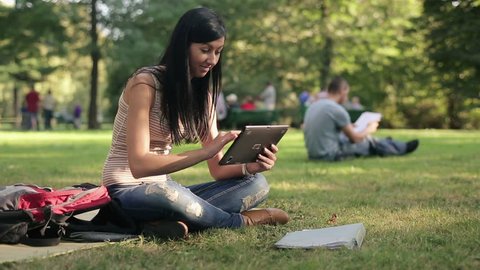 Young female student with tablet computer in the park
