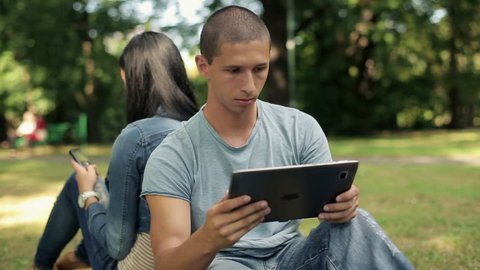 Young student with tablet computer in the park