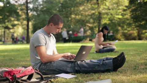 Young student with laptop in the park