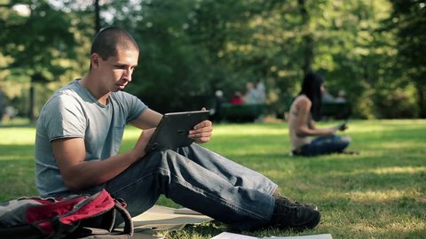 Young student with tablet computer in the park
