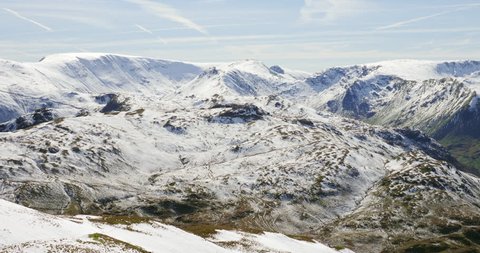 Winter  snow covered mountains in the Eastern Fells of the English Lake District. Summits of High Street, Hartsop Dodd, Stony Cove Pike as well Brothers Water lake and the road, Kirkstone Pass.