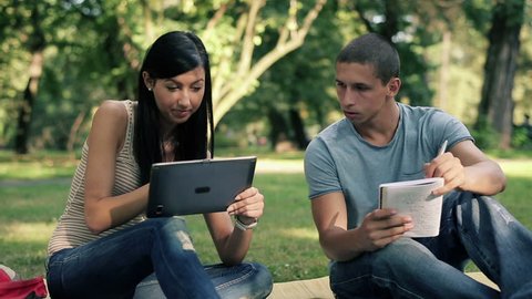 Young students with tablet computer in the park