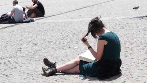 PARIS, FRANCE - MAY 23, 2017: Student Girl Sit On Pedestrian Square Cobblestone Read Leaf A Book Near Pompidou Center In Paris