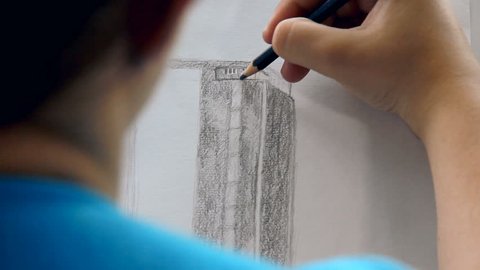 Drawing a business skyscraper with pencil and without other tools. Young woman wanted to be an architect.