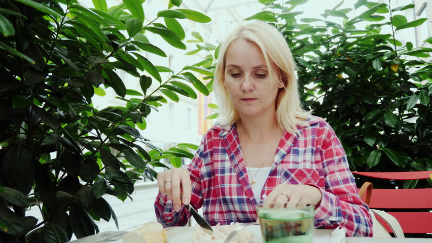 Young woman eating at a cafe on the summer ground. The city of Graz in Austria.