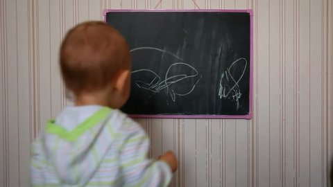 baby draws on chalkboard