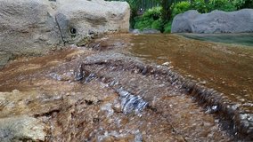 SLOW MOTION of Waterfall on rough rocks closeup in nature background