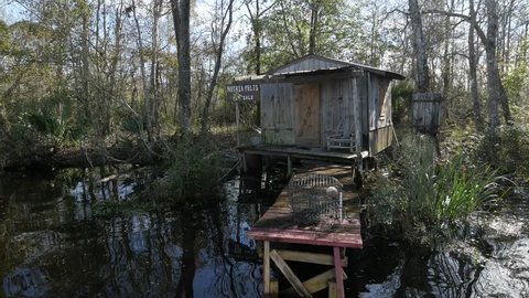 NEW ORLEANS—An added attraction to tourists who do the swamp tours is this small wooden cottage with a dingy and abandoned boat in the swamps of New Orleans, Louisiana, January 2017.  