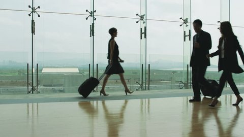asian business traveler walking in airport terminal building. 
