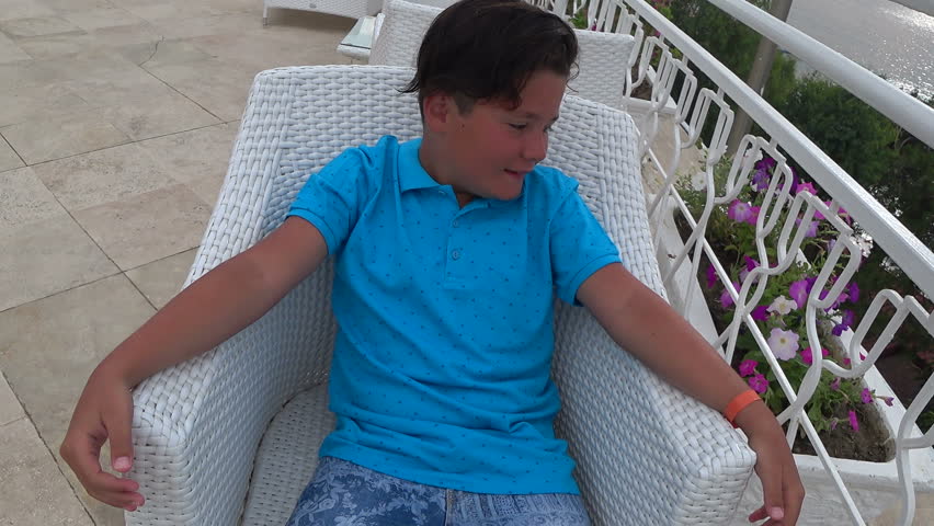 Teenage boy asleep on the chair at the oudoor