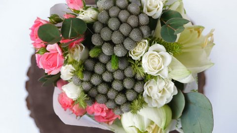 Top view, close-up of a bouquet of flowers, rotation , consists of eucalyptus, cineraria, Rose cream grace, Rose barbados, Eustoma, solidago, Santini , feverweed, Brunia green.