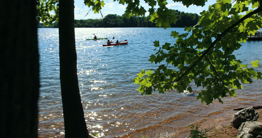 People canoeing on a beautiful lake at sunset. 3 Axis Gimbal tracking shot.