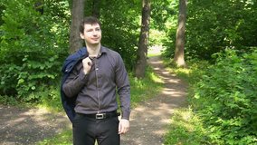 a young businessman goes through the woods on a Sunny day.slow motion