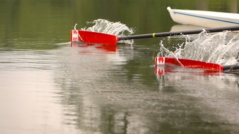 Competitions in rowing. Paddle in the water. Water splashes. Slow motion.