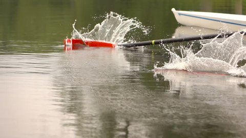 Competitions in rowing. Paddle in the water. Water splashes.