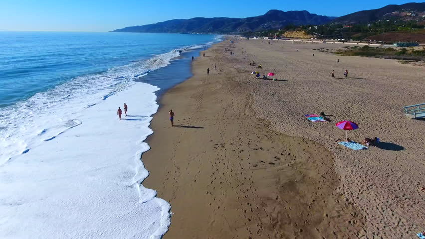Exciting low flying aerial drone footage of vacationing tourists, waves and sunshine on the beautiful shores of landmark Malibu, California. Terrific 4K aerial clips for b-roll, titles, marketing... 