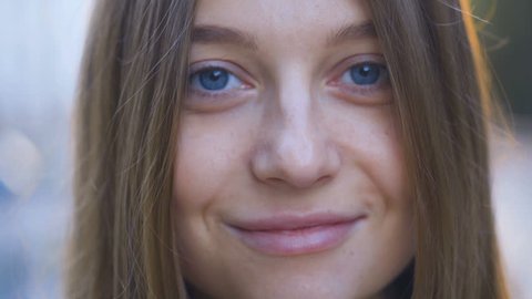 Close-up portrait of attractive smiling young woman in urban environment