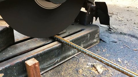 worker cut steel rod using power tool cutting machine