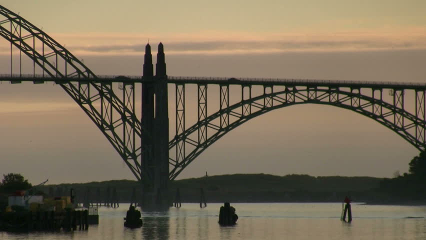 Traffic drives over the Newport Bay Bridge while birds fly around
