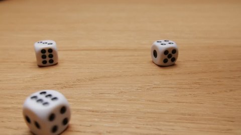 Dice rolling on the brown table. Slow motion. Close-up.