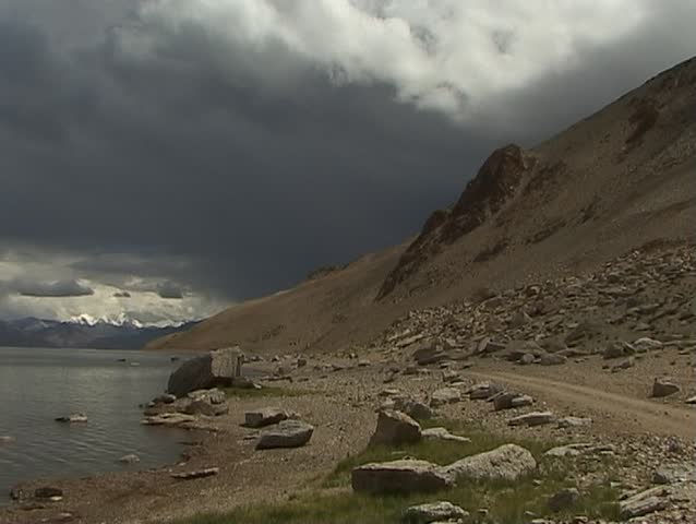 Big truck traveling along lake in the Himalayas