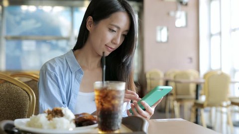 Woman use of smart phone in restaurant 