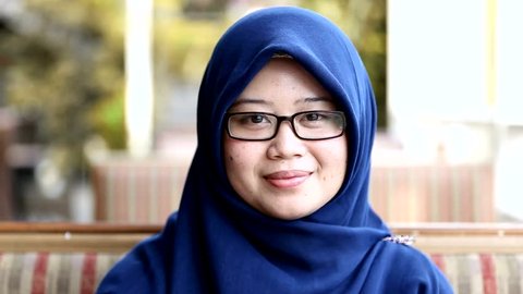Portrait of muslim south east asian woman with hijab is smiling at the cafe