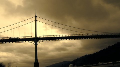 Storm clouds moving over the St. John's Bridge with traffic driving over in Portland Oregon, real time.