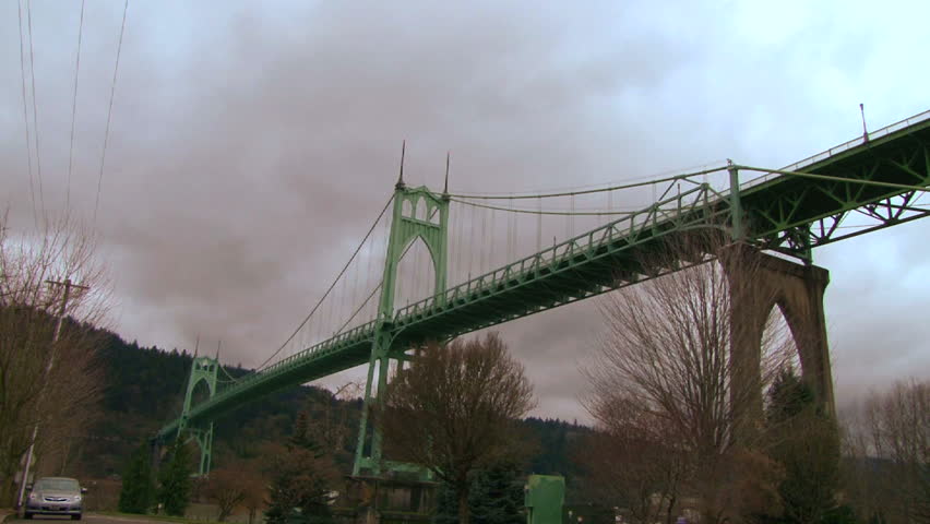 Storm clouds moving over the St. John's Bridge with birds flying in Portland