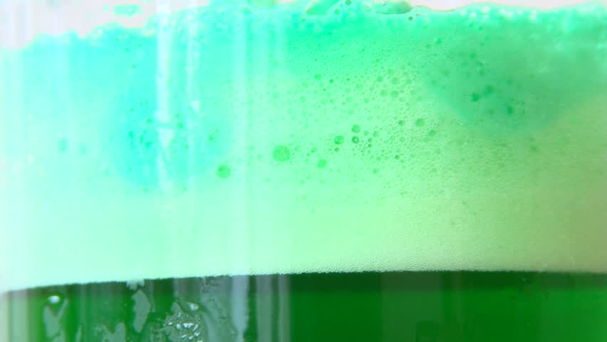 Green beer pouring in glass celebrating St Patrick's Day.