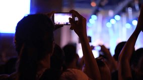 People shooting video with smartphones at concert