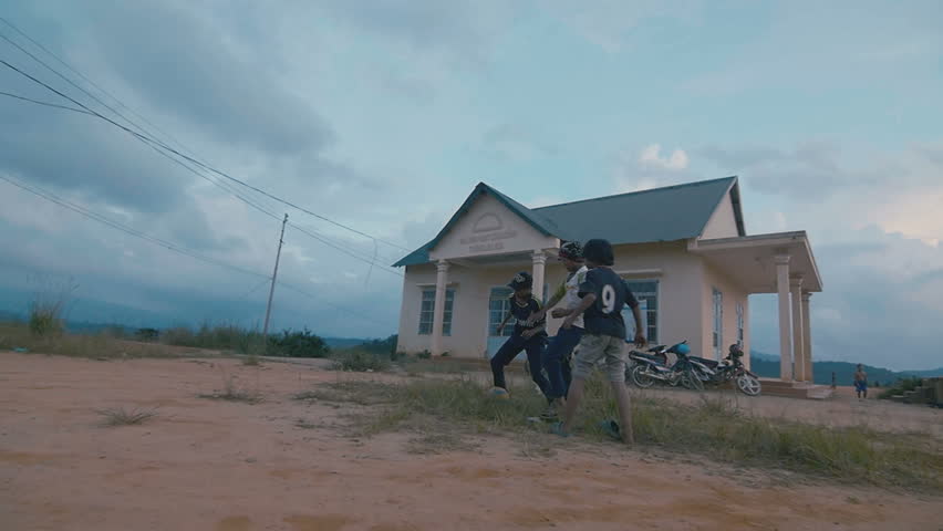 Little boys kick the ball on the sand. Slow motion