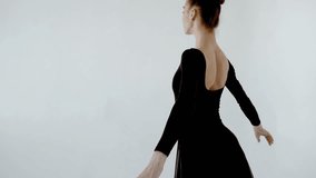 The ballerina excellently dances in a white dance hall close up at the beginning of the video slow motion 120fps