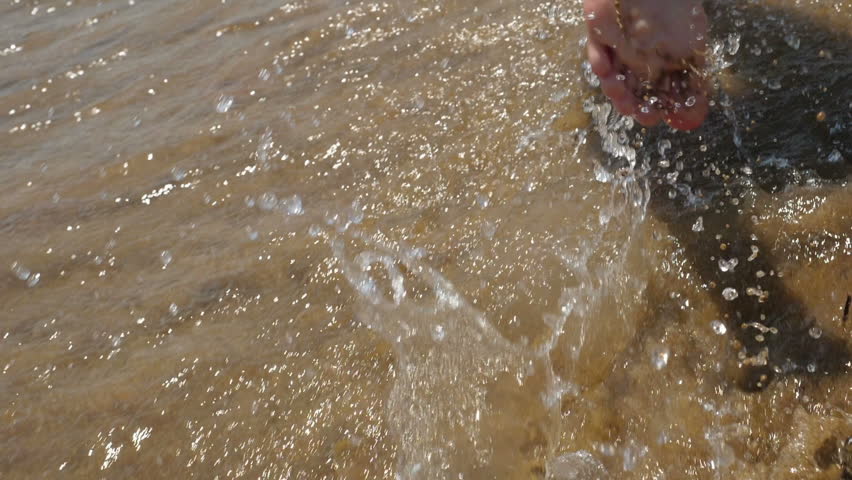 Little girls run barefoot on the sand beach. Slow motion of female legs running splashing into water.