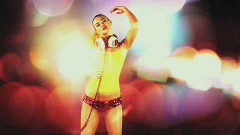a sexy gogo dancer shot in a studio dancing agaisnt green screen with disco style background added