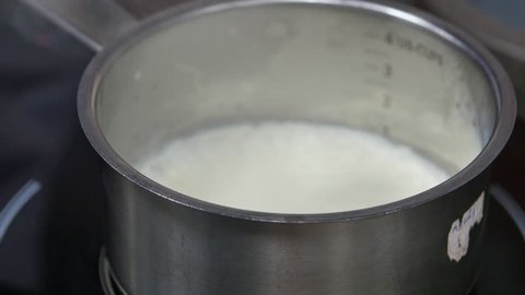 Boiling soy milk with thin yuba or tofu film in a steel pot. Hot fresh milk and gypsum