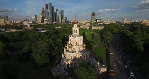 4K aerial video footage view of beautiful Church of Pokrova in Fili, place of Pushkin's wedding, background view of Moscow City tall skyscrapers in Moscow, capital of Russia in sunny summer afternoon