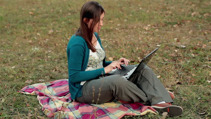 girl working at a laptop in the park