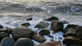 Slow motion sea waves splashing against rocks