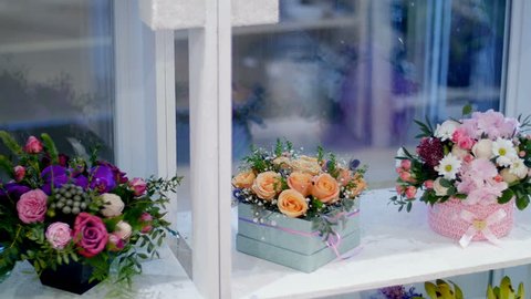 Flower shop, on the show-window, there are a lot of bouquets of flowers , floral stylish compositions in colorful boxes with different flowers