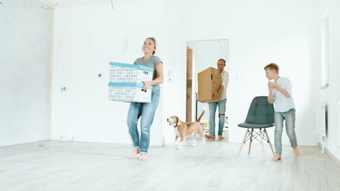  Young family with beagle dog brings the boxes in new house