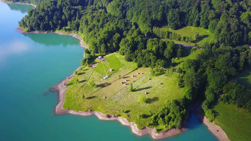 4K aerial footage of Paltinul Lake, which is a reservoir lake located in a picturesque mountain area in the Doftana basin.