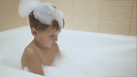 Baby plays with bubbles while taking a bath