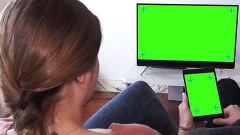 Couple Watching Videos At Home, Panning Behind Models Shoulders. Pan camera on couple watching television and tablet green screen. Shot behind models shoulders