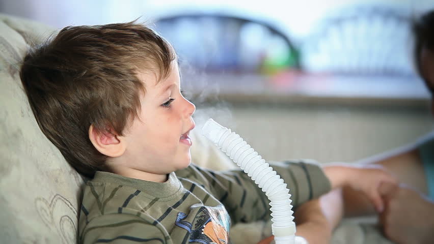 Mother and little boy inhaling medicine using nebulizer